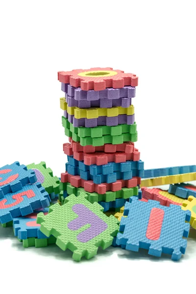 Turm aus bunten Buchstaben Puzzle-Matte isoliert in weißem Hintergrund — Stockfoto