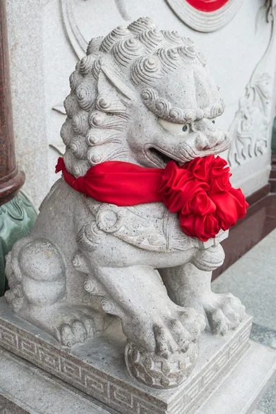 Estátua de leão chinês com fita vermelha — Fotografia de Stock