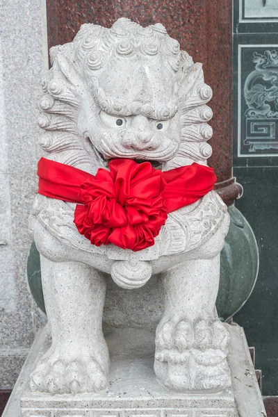 Estátua de leão chinês com fita vermelha — Fotografia de Stock