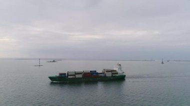 Kargo konteynır gemisi açık denize açılacak. Hava aracı atışı. Baltık Denizi. 4K 50fps