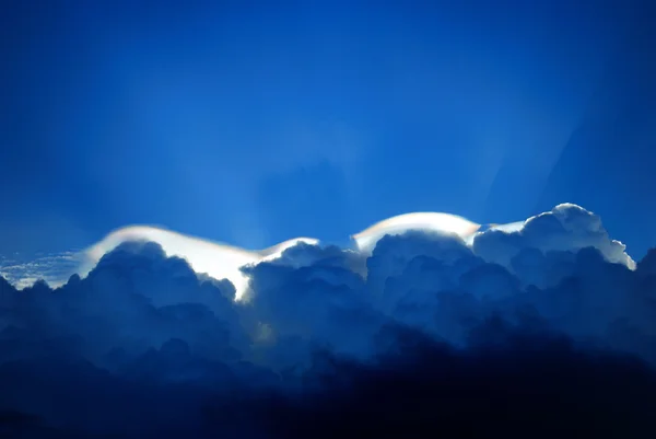 Sunbeam shining through above the clouds and blue sky — Stock Photo, Image