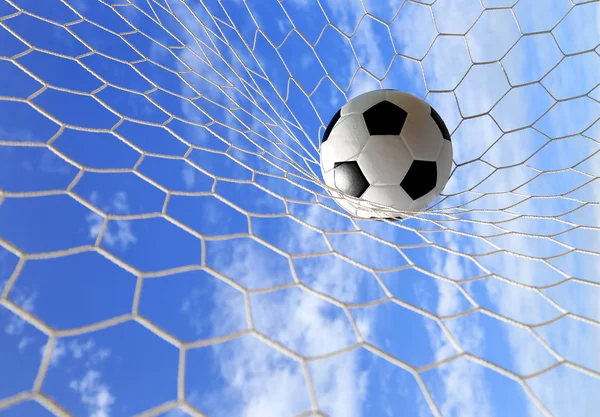 Pallone da calcio in rete su cielo blu — Foto Stock