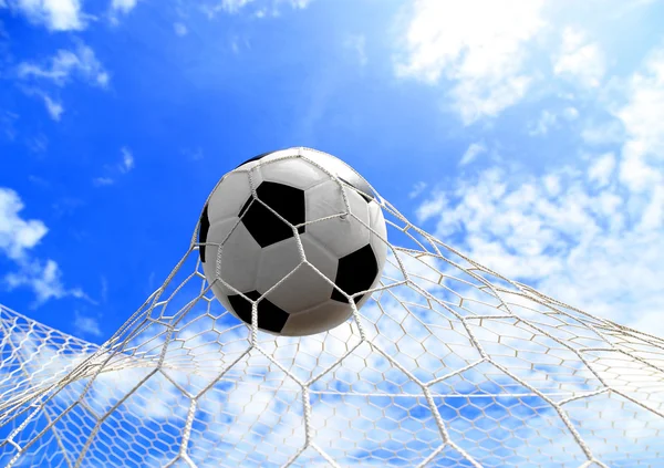 Pelota de fútbol en red en el cielo azul — Foto de Stock