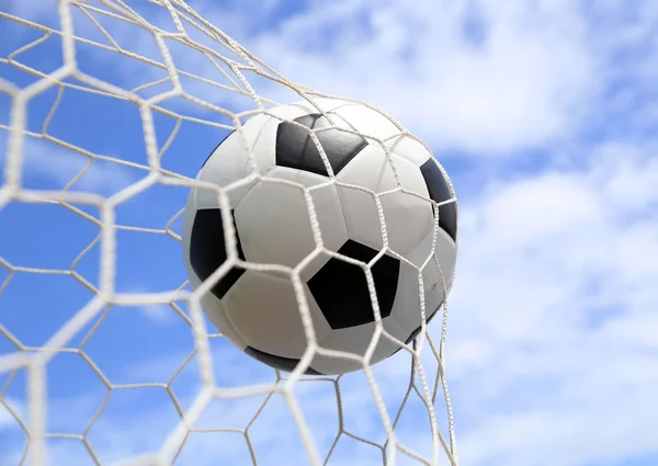 Pallone da calcio in rete su cielo blu — Foto Stock