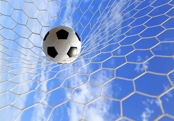 Pallone da calcio in rete su cielo blu — Foto Stock