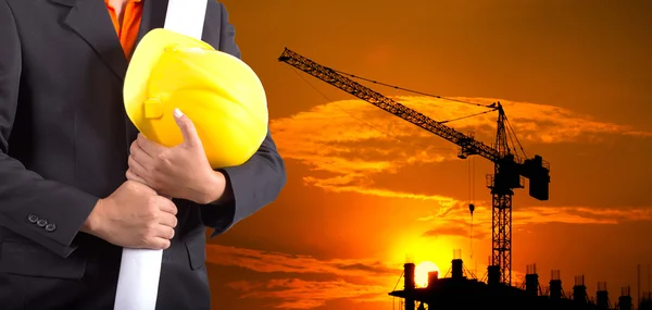 Ingeniero que sostiene el casco amarillo para la seguridad de los trabajadores en backgroun —  Fotos de Stock