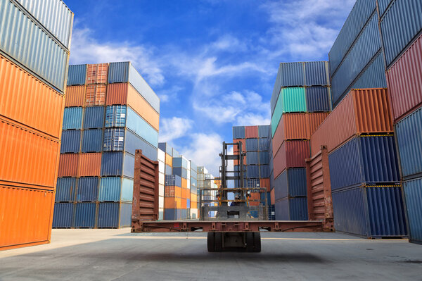 Forklift handling the flat rack container box at dockyard