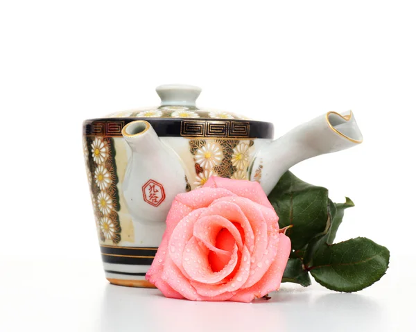 Глиняный чайник с розовой розой — стоковое фото