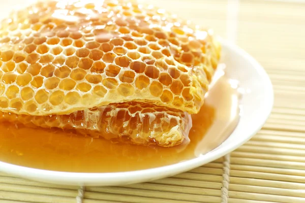 Fermer les rayons de miel doux sur un tapis de bambou — Photo