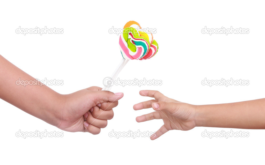 Color lollipop in child hand isolated on white 