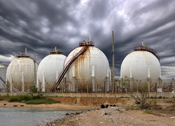 Grandes tanques de aceite industrial en una refinería y sistema de drenaje con —  Fotos de Stock