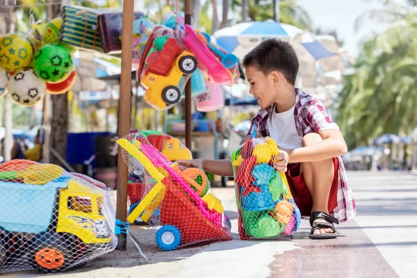 Chico Lindo Seleccionando Juguetes Plástico Playa Tienda Aire Libre Venta — Foto de Stock