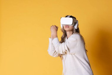 İnteraktif sanal gerçeklik gözlüksüz. VR ya da Sanal Gerçeklik başlığı takan genç kadın öğrenmek, seyahat etmek ya da oyun oynamak için dijital simülasyon dünyasına girmeye hazır..