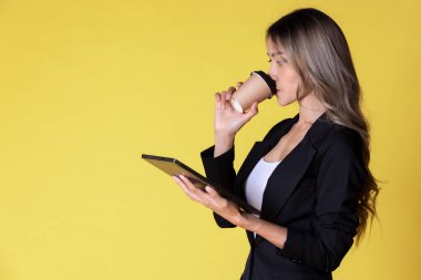 Bir fincan kahve ve tabletle izole edilmiş güzel bir kız.