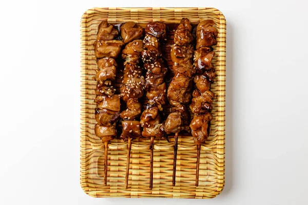Teriyaki chicken skewers on a white background