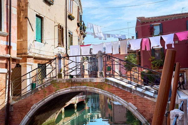 穿过意大利威尼斯运河的洗衣线 在城市建筑之间和桥以上的晾衣绳上挂着洗衣房 威尼斯老旧砖房窗户之间的服装线条 — 图库照片