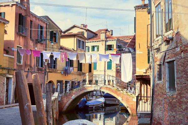 穿过意大利威尼斯运河的洗衣线 在城市建筑之间和桥以上的晾衣绳上挂着洗衣房 威尼斯老旧砖房窗户之间的服装线条 — 图库照片