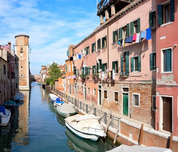 意大利威尼斯运河边的清洗线 城市建筑之间的晾衣绳上挂着洗衣店 系泊的船 砖塔威尼斯老旧砖房窗户之间的服装线条 — 图库照片