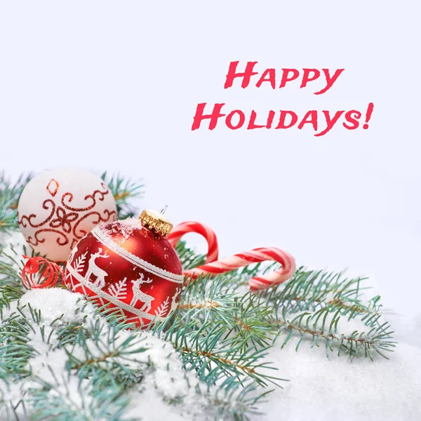 テキストハッピーホリデー 雪の下で自然のモミの小枝と抽象的な冬の青い白い背景に赤と白のクリスマスの泡とキャンディーの缶上記のテキストスペース メリークリスマスとハッピーニューイヤー — ストック写真