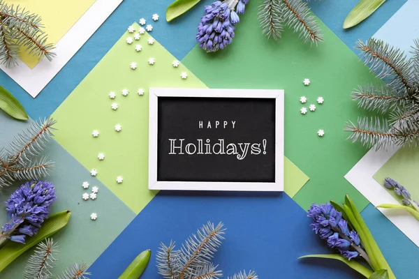 ブラックボード上のテキストハッピーホリデー 青のヒヤシンスの花とモミの小枝と緑 白の層状の幾何学的な紙の背景 冬の季節の装飾 紙サークル コンフェッティ — ストック写真