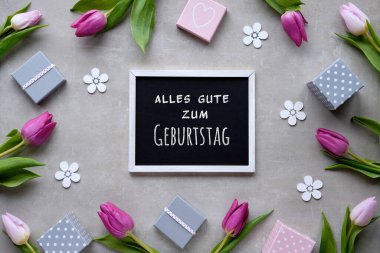 Alles Gute Zum Geburtstag 'a Almanca Mutlu Yıllar demek. Bahar dairesi hediye kutularıyla, mor lalelerle bej taşın üzerinde deco çiçekleriyle kaplıydı. Doğal çiçeklerle dolu bahar tatili geçmişi.
