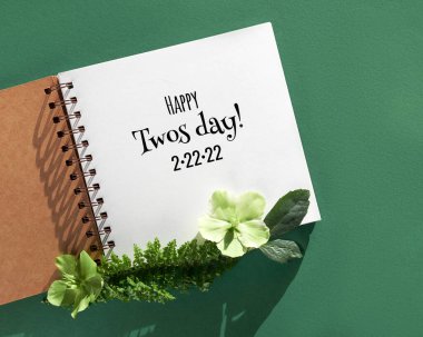 Mutlu İkiler Günü 2.22.22, aynı zamanda Twosday olarak da bilinir, yeşil renkli İkiler Günü, kare şeklinde sarı renkler. Kış çiçeği aranjmanı, beyaz kağıt defter, tebrik mesajlı albüm. 22 Şubat 2022 Salı
