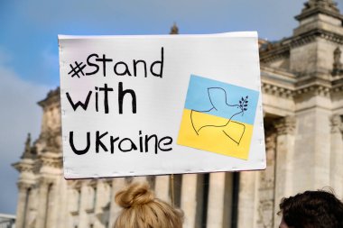 Packard Ukrayna, Ukrayna sarısı mavi bayrak ve barış güvercini ile duruyor. Ukrayna 'daki savaşı protesto etmek. Berlin 'in merkezinde Alman Reichstag Binası.