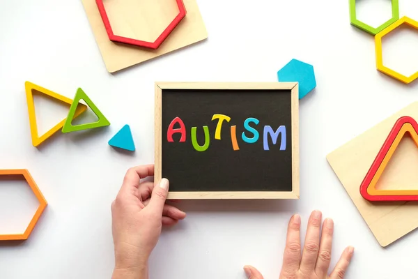 Tekst Autisme Woord Schoolbord Regenboogkleuren Nest Hout Driehoeken Zeshoeken Verschillende — Stockfoto