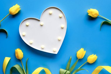 Barış güvercini, kağıt origami. Ukrayna 'ya barış. Sarı laleler, çiçekler, mavi arka planda. Kopyalama alanı, metin için yer. Üst görünüm, düz görünüm, kavram arkaplan.