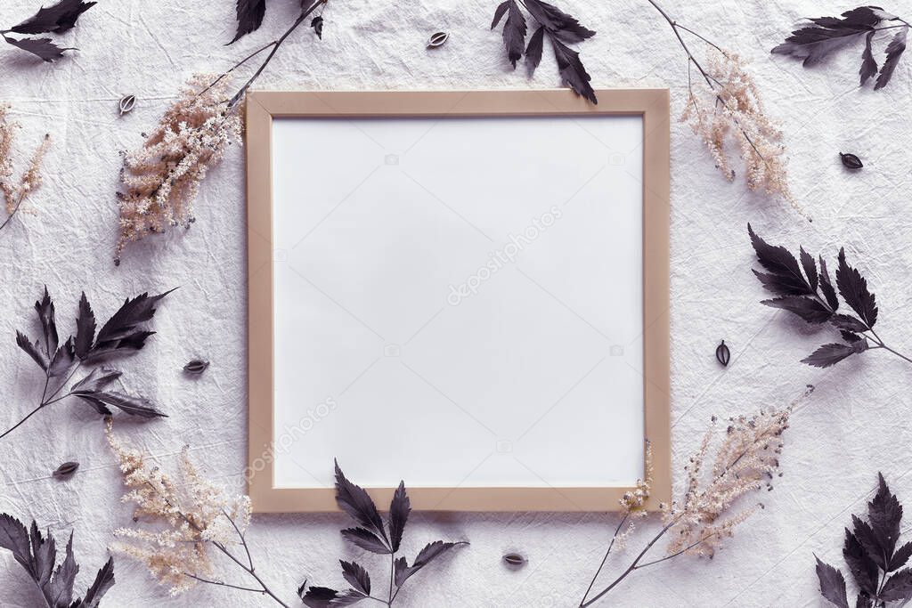 Boho mockup. Frame with wild flowers, tinted in coffee tones. Text space, copy-space. Natural materials, flat lay on off white textile. Pale cream colored prachtspiere flowers.
