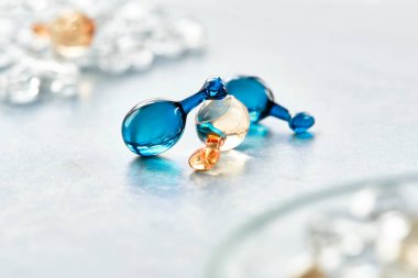 Serum capsules for healthy skin. Anti-wrinkle rejuvenation skin treatment. Beauty product presentation, close-up in blue and orange colors.