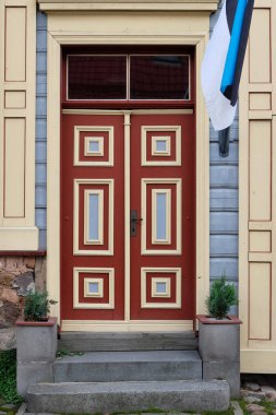 Kahverengi ahşap kapılar, restore edilmiş eski ahşap tarihi eve giriş taze boyanmış gri ve krema. Tartu, Estonya. Avrupa tarihi mimari detayları.