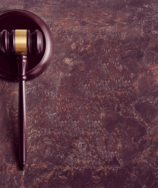 Dark polished wooden law hammer or gavel on aged wooden table. Concept background for legal buisiness images - advice, consultation, counseling or law education. Copy-space, text place.