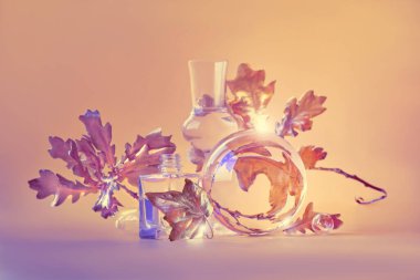 Biyofilik sonbahar geçmişi. Altın sarısı meşe yaprakları şeffaf cam kavanozlar ve küçük şişelerle bozulmuş. Tek renkli turuncu bej toprak renginde çiçek elementleri eşleşen arkaplanda yansımaları var..