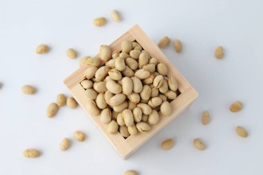Ölçüm kutusunda kavrulmuş soya fasulyesi beyaz arka planda izole edilmiş.