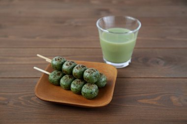 Dango mugwort hamur tatlısı Japon pastası. Masada izole edilmiş yeşil çay.