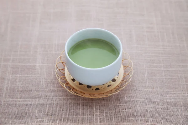 Гарячий зелений чай з молочним лате ізольований на столі — стокове фото