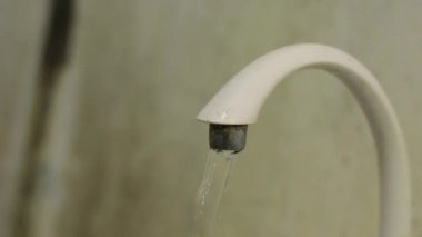 Kirli bir tuvalet musluğuna su damlatıyor.