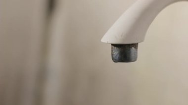 Kirli bir tuvalet musluğuna su damlatıyor.