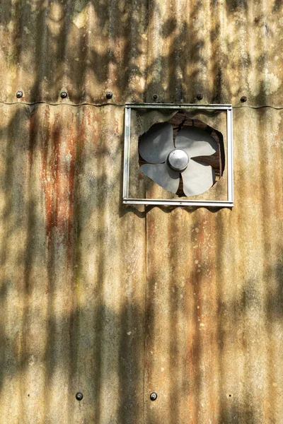 Terk edilmiş bir binanın eski metal egzoz vantilatörü.