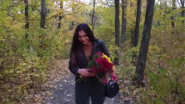 Lány virágokkal sétál az őszi erdőben — Stock videók