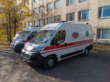 Evin yakınındaki ambulans ve sarı ağaçlar.