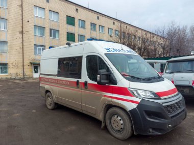 Yüksek bir binanın yakınındaki kirli ambulans.