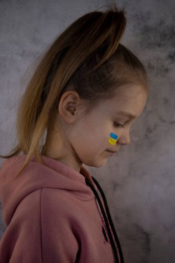 Ukrayna bayrağı taşıyan bir çocuk ağlıyor. Üzüntü, umut özlemi. Gözyaşı makrosu. Savaştan kalan çocukların gözyaşları. Sivillerin tahliyesi. Ukrayna 'ya Özgürlük