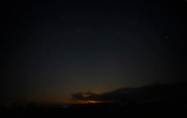 Orangener Nachthimmel mit Sternen und Wolken. — Stockfoto