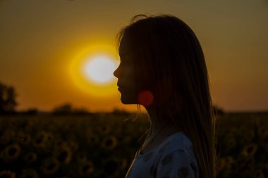 Gün batımının arka planında bir çocuğun silueti