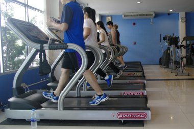 threadmill spor salonunda çalışan insanlar
