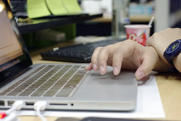 Hand am Computer am chaotischen Arbeitstisch — Stockfoto