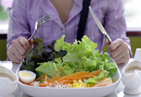 Chica con cuchillo y tenedor comer ensalada —  Fotos de Stock