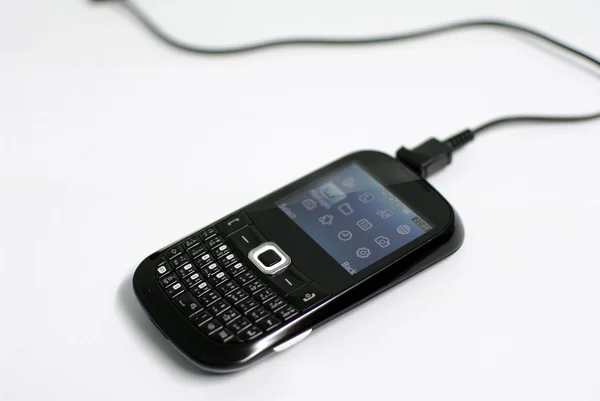 Black old smartphone charging — Stock Photo, Image